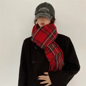 Gros plan sur la texture de l'écharpe d'hiver à carreaux rouges, douce et frangée.