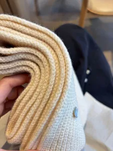 Detailed shot of thick warm wool-blended knitted scarf texture close up, solid color cozy neck warmer.