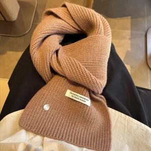 Cozy brown wool blend knitted scarf with handmade label and cute shell button for winter.