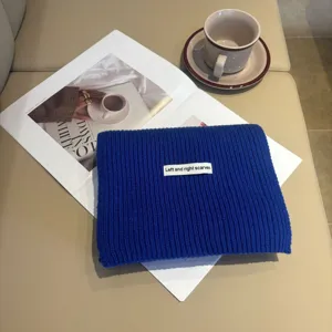 Vista dettagliata della sciarpa in maglia blu, morbida lana, accessorio invernale cosy.