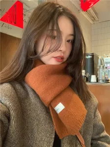 Close-up view of cozy knit scarf texture, showing soft caramel winter accessory details.