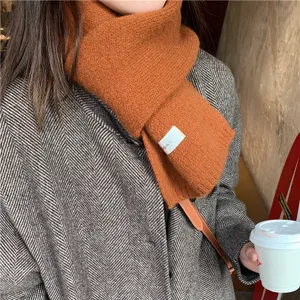 Cozy winter knitted scarf in solid orange color, soft warm thick material for cold weather daily wear.