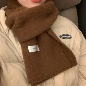 Brown knitted winter scarf for women, warm cozy daily neckwear accessory detail.