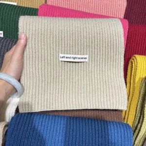 Primo piano dettaglio di scaldacollo in maglia a coste con consistenza morbida e calda.