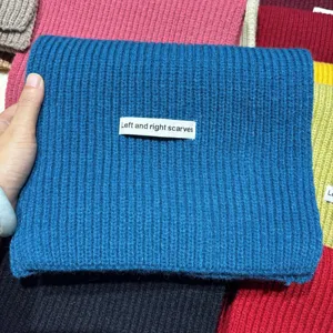Primo piano della sciarpa in maglia a coste blu con trama e dettaglio morbidi.
