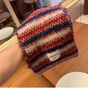 Detailed view of the multi-color striped knitted scarf, soft texture with brand tag design.