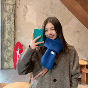 Detailed close-up shot of a stylish blue knit winter scarf worn by a model, cozy and warm apparel.