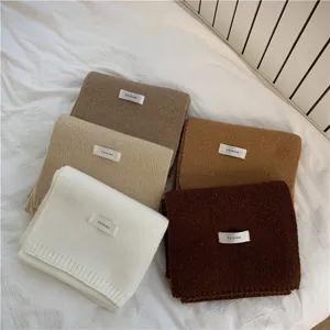 Detailed view of winter knitted solid color scarves showcasing soft texture and cozy warmth.