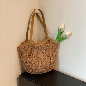 Vista dettagliata della borsa di paglia con manici marroni e trama testurizzata per gite primaverili.