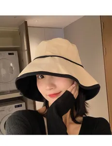 Vue détaillée d'un chapeau bob beige élégant avec bord noir, design de protection solaire.