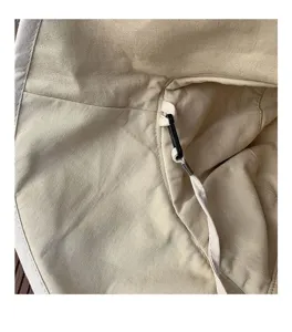 Vue détaillée du chapeau bob en toile beige montrant la doublure et le cordon de serrage.