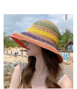 Close-up view of the colorful striped straw sun hat worn outdoors at the beach for summer.