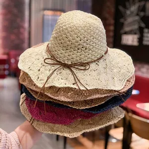 Gros plan de chapeaux de paille tissés élégants empilés dans plusieurs couleurs vibrantes.