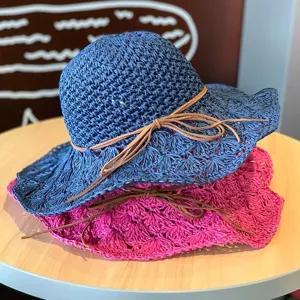 Gros plan détaillé de chapeaux de paille faits main bleus et roses avec nœuds élégants.