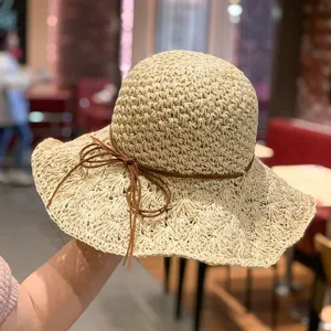 Vue rapprochée d'un chapeau de paille japonais avec lien en cuir marron et large bord.