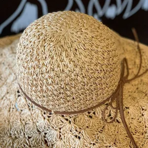 Gros plan sur les détails du chapeau de paille tissé, belle texture crochetée ajourée.