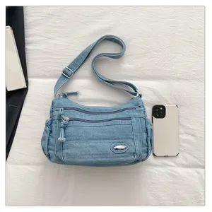 Casual denim shoulder bag with multiple zippered pockets and adjustable strap for daily use.