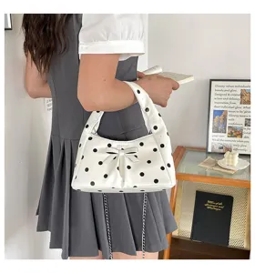 White polka dot underarm bag detail showing cute bow and chain strap design view.