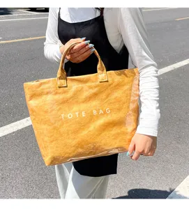 Grande borsa tote impermeabile in PVC trasparente con texture in carta kraft.