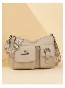 Detailed view of soft leather handbag highlighting stylish textured woven strap and front pockets.