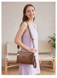 Detailed shot of a stylish brown PU leather crossbody bag worn by a model in lifestyle setting.