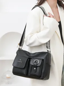 Fashionable black soft leather hobo shoulder bag with wide woven strap and double front pockets.