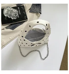 Vintage polka dot underarm bag with chain strap and cute bow, chic retro shoulder handbag.