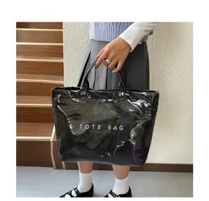 Vista dettaglio borsa tote in PVC nero lucido, borsa spesa impermeabile di grande capacità utile.
