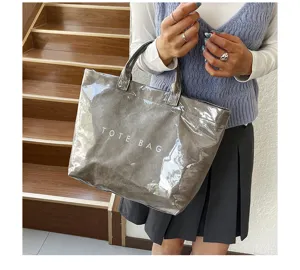 Dettaglio della borsa shopper trasparente in PVC con texture impermeabile e manici robusti.