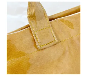 Dettaglio borsa shopper PVC gel con cuciture manico e superficie lucida impermeabile.
