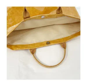 Dettaglio interno borsa tote in PVC impermeabile, grande borsa jelly con bottone magnetico.