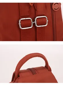 Close-up detail of women backpack rust red shoulder strap metal buckle handle design
