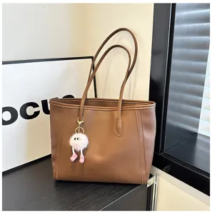 Brown large capacity tote bag detail view with dual straps and cute plush charm.