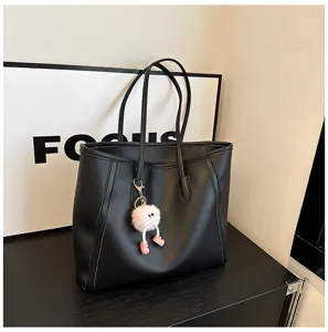 Black large capacity PU leather tote bag with cute fuzzy pink charm, stylish commuting shoulder bag.