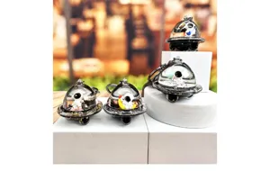 Detailed view of crystal floating astronaut spaceship keychain, transparent capsule design.