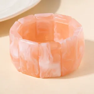Gros plan sur un bracelet extensible en acrylique marbré rose avec maillons rectangulaires