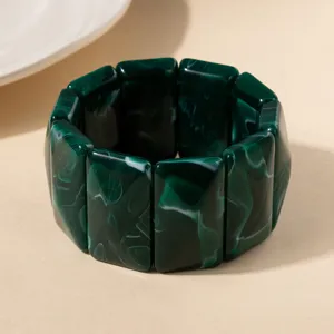 Vue détaillée d'un bracelet élastique en acrylique vert foncé avec texture marbrée