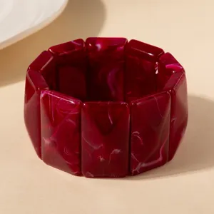 Vue détaillée d'un bracelet jonc en acrylique marbré rouge foncé avec motif tourbillon vintage.