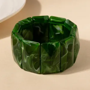 Gros plan sur un bracelet en acrylique marbré vert avec des maillons rectangulaires.