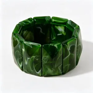 Vue détaillée d'un bracelet en acrylique vert foncé avec des motifs marbrés artistiques.