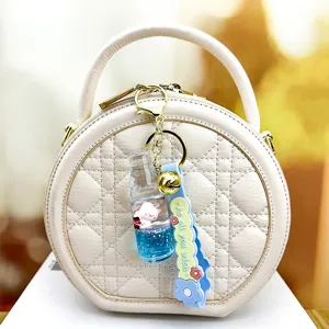 Beige quilted round handbag with cute floating glitter soda bottle keychain pendant stylish bag accessory