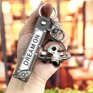 Cute astronaut floating UFO keychain with strap, creative space man bag pendant gift.