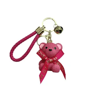 Pink woven texture bear keychain with leather strap and bell, cute cartoon doll bag pendant.