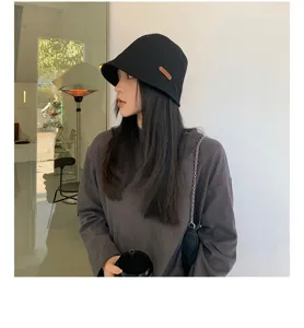 Chapeau bob noir en coton pour femme, bob de style urbain décontracté avec étiquette cuir.