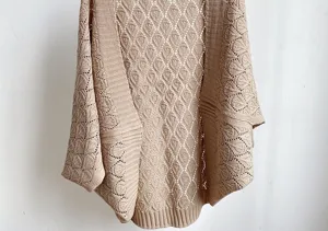 Close-up detail of hollow-out knit cardigan shawl, casual breathable style for daily wear.