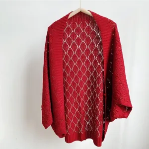 Red hollow knit cardigan detail shot, showcasing the delicate diamond pattern and loose sleeves.