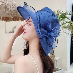 Close-up of blue organza sun hat detail, elegant floral and pearl decoration for summer.