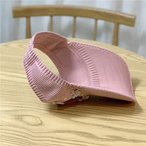 Elegante cappello visiera rosa lavorato a maglia per donna, perfetto per sole estivo.