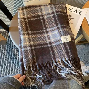Détail d'écharpe à carreaux bleus bruns, tissu doux en mélange de laine et franges.