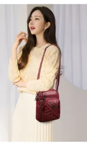 Detailed view of the washed leather crossbody bag worn by model, multi-zipper pocket design.